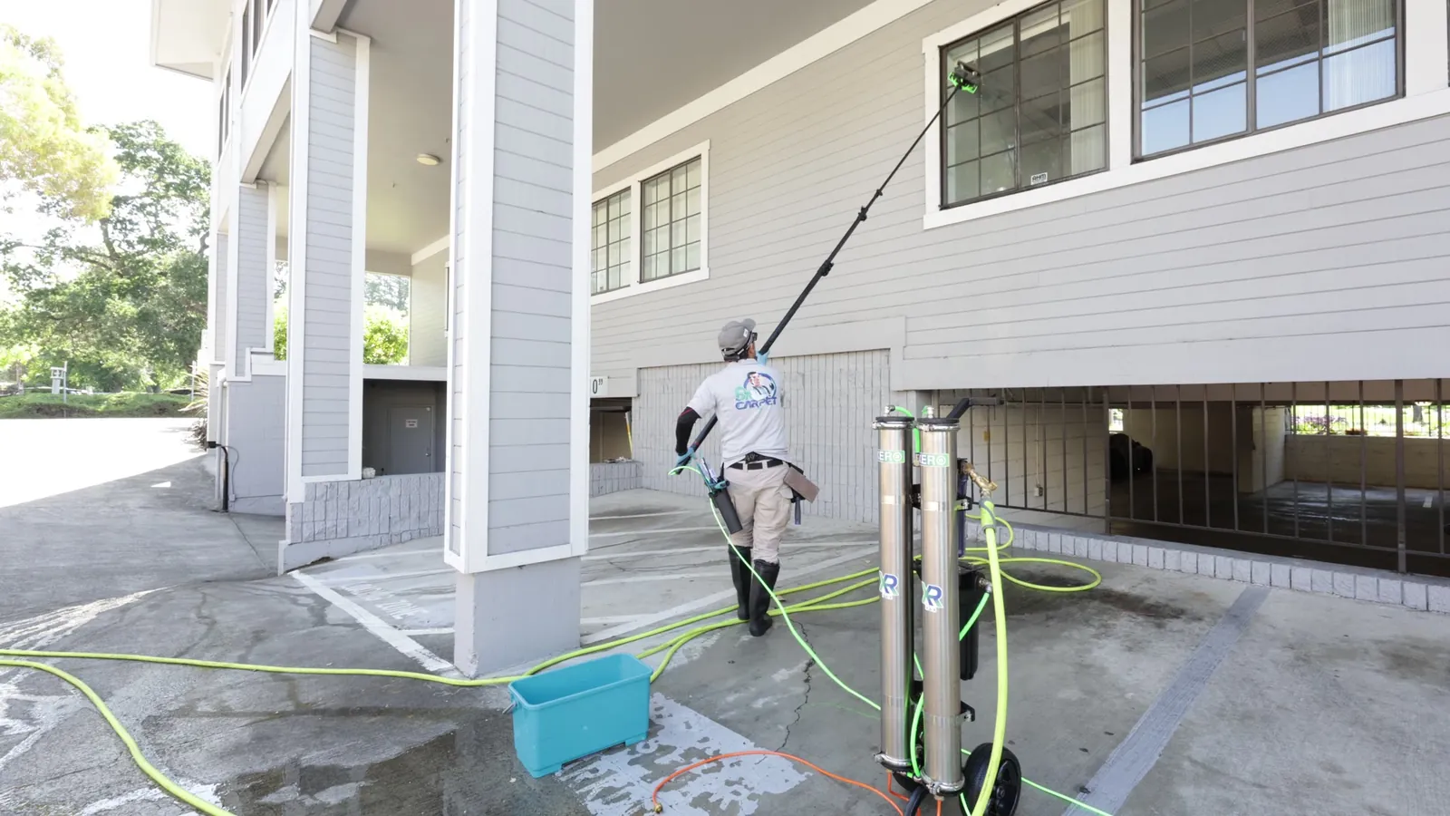Dr. Carpet technician cleaning upper windows with a water-fed pole and the XERO pure water system in Walnut Creek, CA