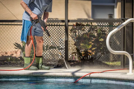Pressure washing the pool coping and deck edge