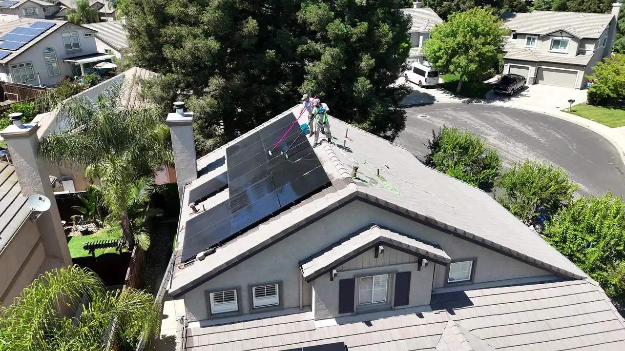 Aerial view of solar panels being cleaned with soft brushes and pure water